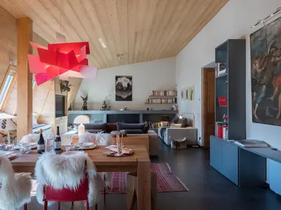 a dining room and living room with a table and chairs at Penthouse Le Paradis I Le Chalet Club in Chamonix-Mont-Blanc