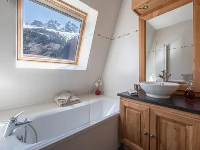 a bathroom with a tub and a sink and a mirror at Penthouse Le Paradis I Le Chalet Club in Chamonix-Mont-Blanc
