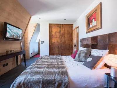 a bedroom with a large bed and a television at Penthouse Le Paradis I Le Chalet Club in Chamonix-Mont-Blanc