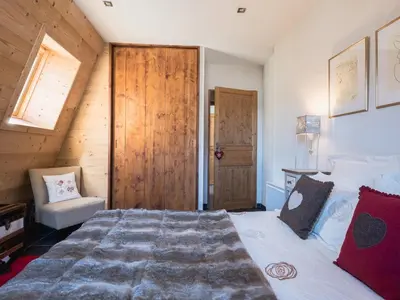 a bedroom with a large bed and a wooden door at Penthouse Le Paradis I Le Chalet Club in Chamonix-Mont-Blanc