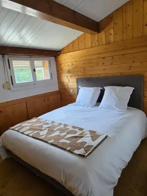 a bedroom with a white bed in a wooden room at Grand appartement proche centre in Megève