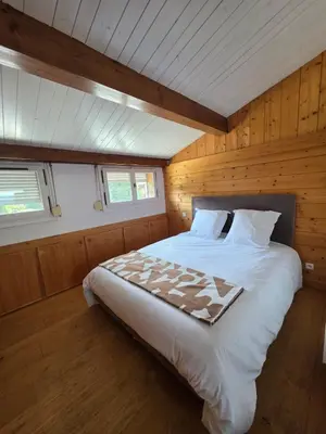 a bedroom with a large bed in a wooden room at Grand appartement proche centre in Megève