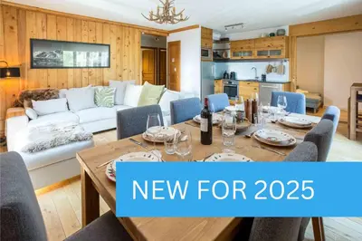 a dining room with a table and a living room with a new for at Val d'Arve Apartment - Chamonix All Year in Chamonix-Mont-Blanc