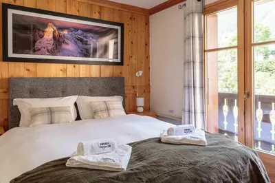 a bedroom with a bed with two towels on it at Val d'Arve Apartment - Chamonix All Year in Chamonix-Mont-Blanc