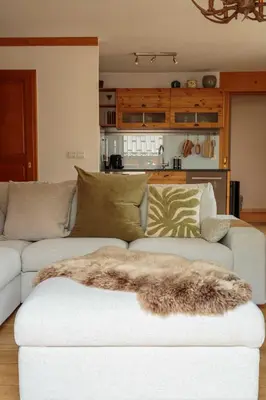 a living room with a white couch with a blanket on it at Val d'Arve Apartment - Chamonix All Year in Chamonix-Mont-Blanc