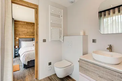 a bathroom with a sink and a toilet and a bed at Chalet Papillon - Alpes Travel - Detached Chalet - Les Praz - Sleeps 8-10 in Chamonix-Mont-Blanc
