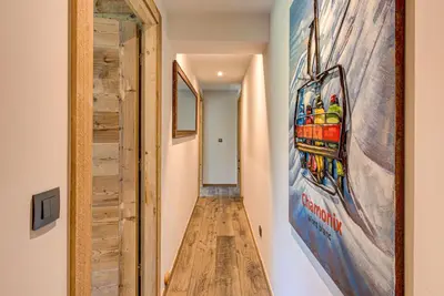 a hallway with a wooden floor and a painting on the wall at Chalet Papillon - Alpes Travel - Detached Chalet - Les Praz - Sleeps 8-10 in Chamonix-Mont-Blanc