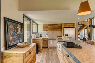 a kitchen with wooden cabinets and a counter top at Chalet Papillon - Alpes Travel - Detached Chalet - Les Praz - Sleeps 8-10 in Chamonix-Mont-Blanc