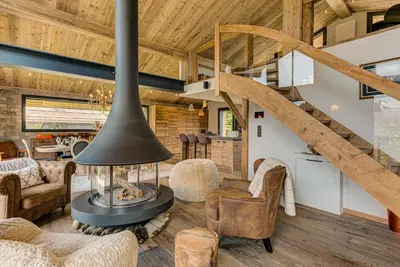 a living room with a fireplace and a staircase at Chalet Papillon - Alpes Travel - Detached Chalet - Les Praz - Sleeps 8-10 in Chamonix-Mont-Blanc