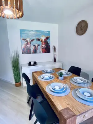 a dining room with a wooden table and blue chairs at 3 cows in Les Contamines-Montjoie