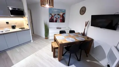 a kitchen and dining room with a wooden table and chairs at 3 cows in Les Contamines-Montjoie