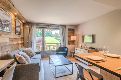 a living room with a couch and a table at Appartement Le clos de Rochebrune - Welkeys in Megève