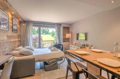 a room with a bed and a table and chairs at Appartement Le clos de Rochebrune - Welkeys in Megève
