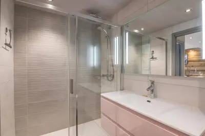 a bathroom with a shower and a sink and a mirror at Appartement Le clos de Rochebrune - Welkeys in Megève