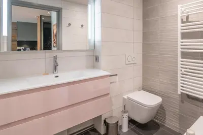 a white bathroom with a sink and a toilet at Appartement Le clos de Rochebrune - Welkeys in Megève