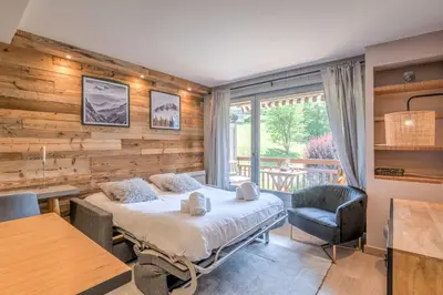 a bedroom with a bed and a desk and a chair at Appartement Le clos de Rochebrune - Welkeys in Megève