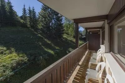 a porch with white chairs and a large window at Résidence Le Relax - Megève Centre in Megève
