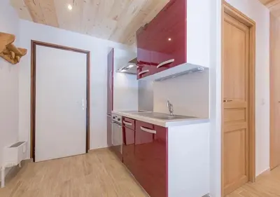 a kitchen with a sink and a red cabinet at Résidence Le Relax - Megève Centre in Megève