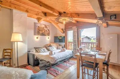 a bedroom with a bed and a dining room with a table at Appartement Warens - Welkeys in Megève