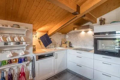 a kitchen with white cabinets and a sink at Appartement Warens - Welkeys in Megève