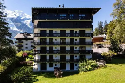 a building with balconies and a mountain in the background at Le Brevent apartment -Chamonix All Year in Chamonix-Mont-Blanc