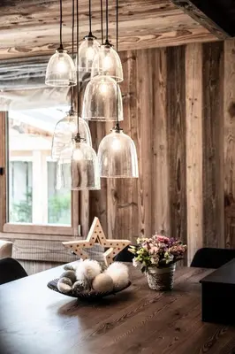 a dining room with a wooden table with several lights at Apartment Brume Megève - by EMERALD STAY in Megève