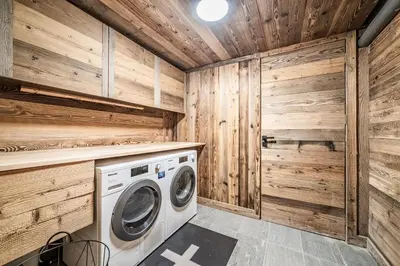 a laundry room with wooden walls and a washer and dryer at Apartment Brume Megève - by EMERALD STAY in Megève
