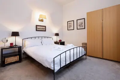 a bedroom with a bed and a wooden cabinet at Le Majestic 76 - Chamonix All Year in Chamonix-Mont-Blanc