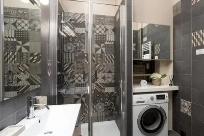 a bathroom with a shower and a washing machine at Le Majestic 76 - Chamonix All Year in Chamonix-Mont-Blanc