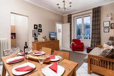 a dining room and living room with a table and chairs at Le Majestic 76 - Chamonix All Year in Chamonix-Mont-Blanc