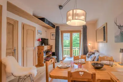 a kitchen and dining room with a table and chairs at Studio Montée du Calvaire - Welkeys in Megève