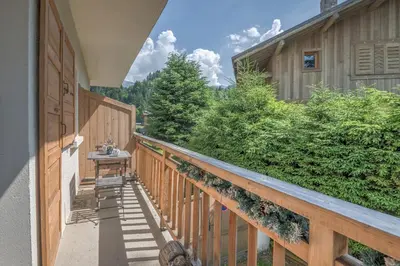 a balcony of a house with a wooden fence at Studio Montée du Calvaire - Welkeys in Megève