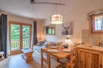 a living room with a table and a couch at Studio Montée du Calvaire - Welkeys in Megève