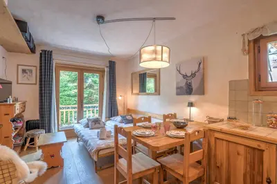 a living room with a table and a couch at Studio Montée du Calvaire - Welkeys in Megève