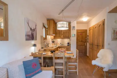 a kitchen and dining room with a table and chairs at Studio Montée du Calvaire - Welkeys in Megève