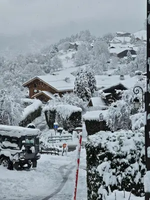 a snow covered yard with a bus and a house at Chalet Double M I Le Chalet Club in Combloux