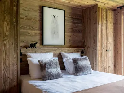 a bedroom with wooden walls and a bed with pillows at Chalet Double M I Le Chalet Club in Combloux