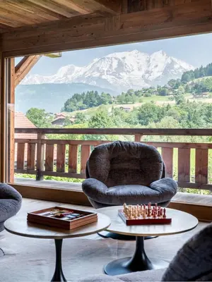 a living room with a chair and a table with chess at Chalet Double M I Le Chalet Club in Combloux