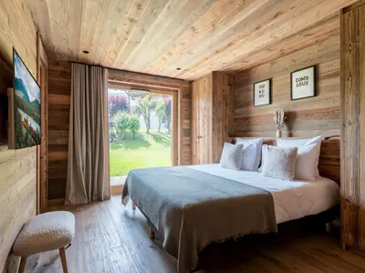 a bedroom with a bed and a large window at Chalet Double M I Le Chalet Club in Combloux