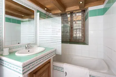 a bathroom with a sink and a tub and a mirror at Lou Lou Apartment - Chamonix All Year in Chamonix-Mont-Blanc