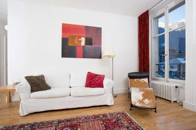 a living room with a white couch and a chair at Mont Blanc 98 Apartment - Chamonix All Year in Chamonix-Mont-Blanc