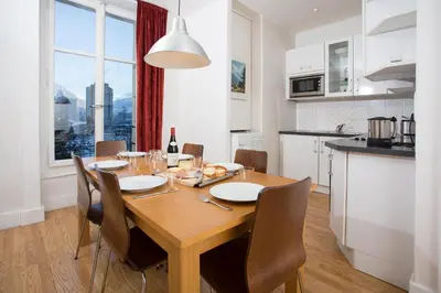 a kitchen and dining room with a wooden table and chairs at Mont Blanc 98 Apartment - Chamonix All Year in Chamonix-Mont-Blanc