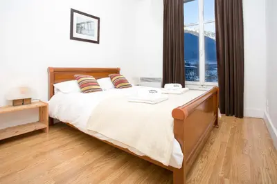 a bedroom with a large bed with a large window at Mont Blanc 98 Apartment - Chamonix All Year in Chamonix-Mont-Blanc
