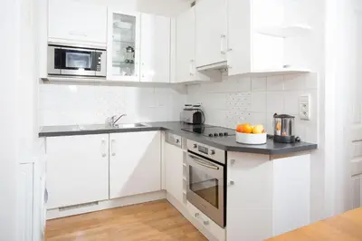 a kitchen with white cabinets and a bowl of fruit on the counter at Mont Blanc 98 Apartment - Chamonix All Year in Chamonix-Mont-Blanc