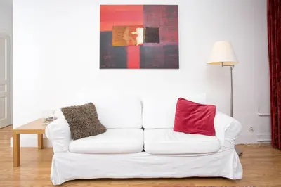 a white couch with two red pillows sitting in a living room at Mont Blanc 98 Apartment - Chamonix All Year in Chamonix-Mont-Blanc