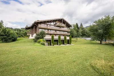 a house on a hill with a large yard at Apartment with balcony 10 min walk from the slopes in Megève