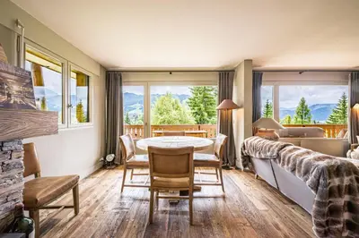 a room with a table and chairs and a bedroom at Apartment with balcony 10 min walk from the slopes in Megève
