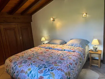 a bedroom with a bed with a colorful comforter at Le Mont - Vue montagne - Parking - Wifi - Nature in Demi-Quartier