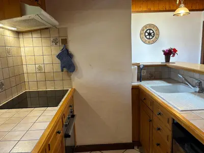 a kitchen with a sink and a clock on the wall at Le Mont - Vue montagne - Parking - Wifi - Nature in Demi-Quartier