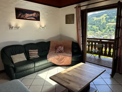 a living room with a green couch and a table at Le Mont - Vue montagne - Parking - Wifi - Nature in Demi-Quartier